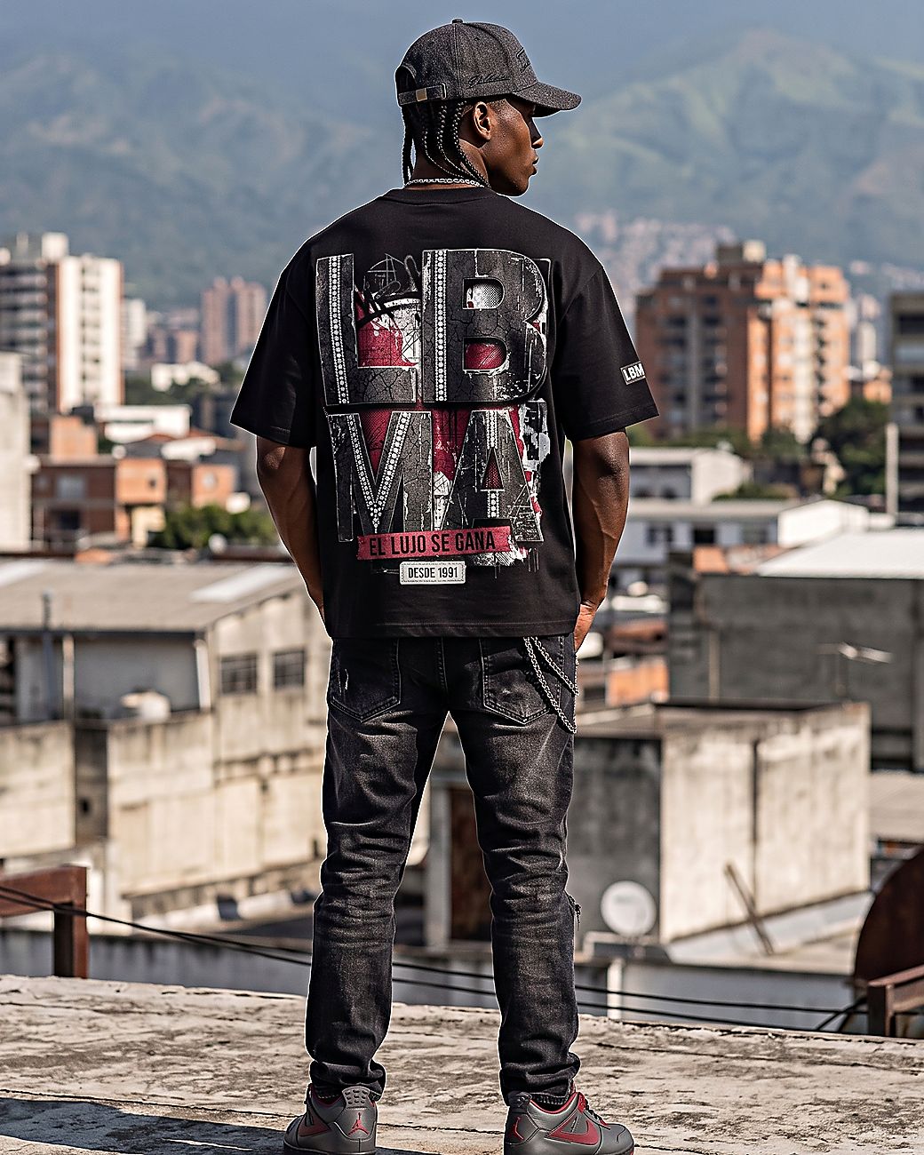 Camiseta oscura con el diseño grande en la espalda, vista de espaldas en una azotea